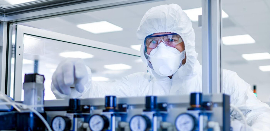 Wissenschaftler in Schutzkleidung arbeitet im Labor an präzisen Messgeräten.