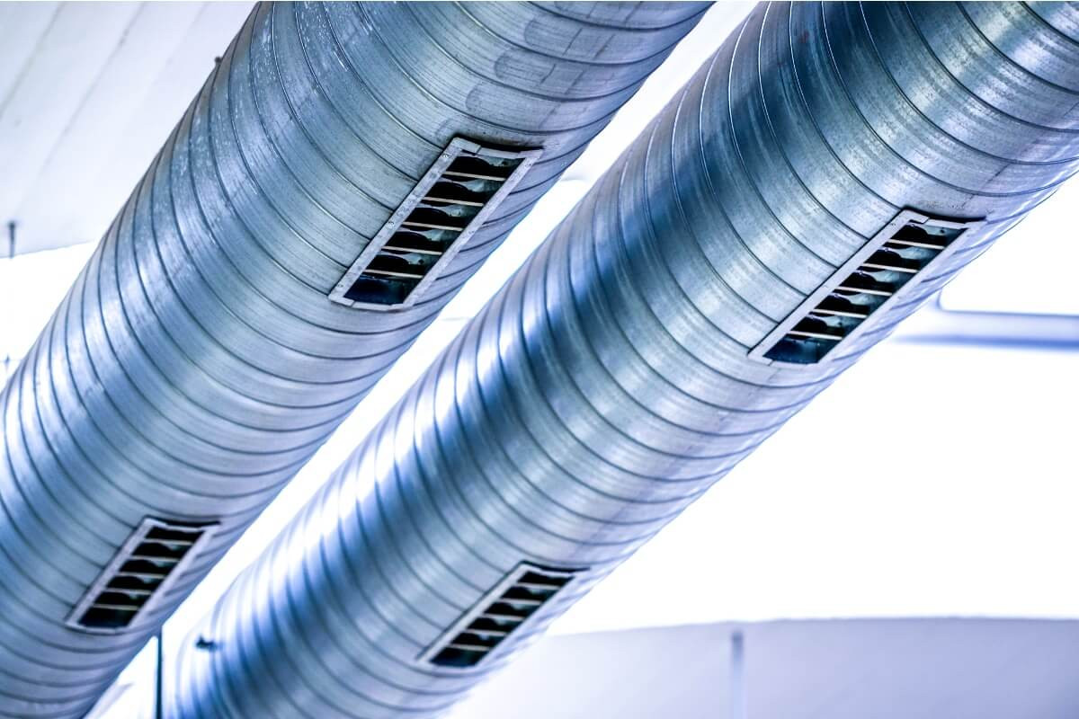 Industrielle Lüftungsrohre mit Lüftungsgittern, moderne HVAC-Systeme.
